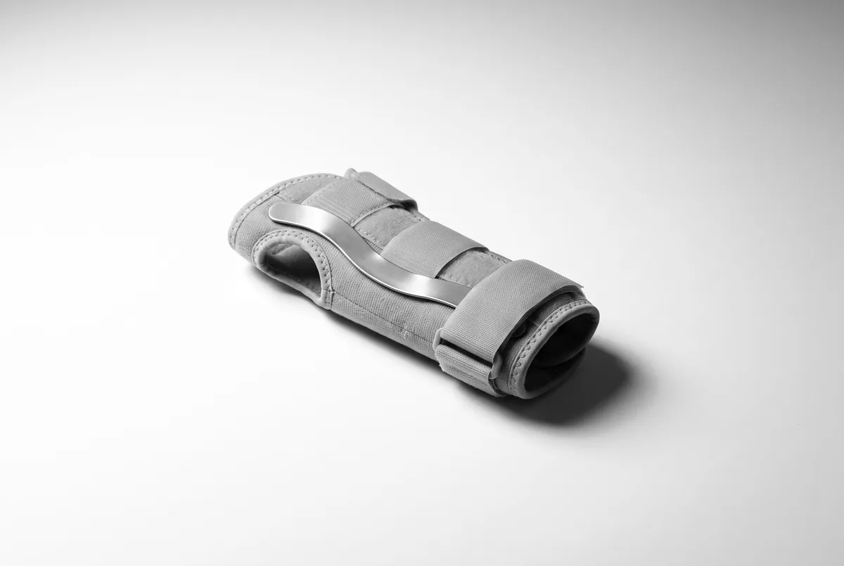 A plain wrist splint with a contoured support stay, photographed on a white surface.